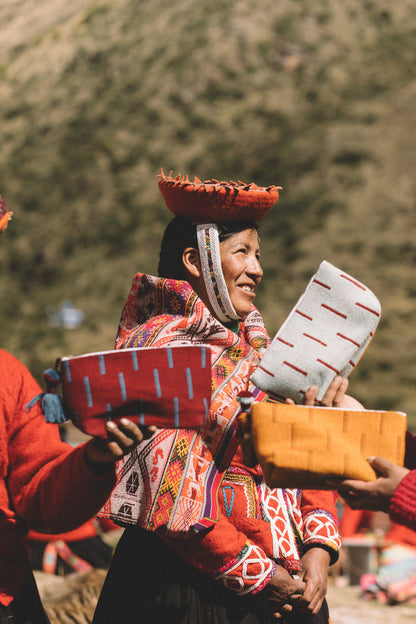 Artisan partner in traditional attire holding cosmetic bags from handmade textile